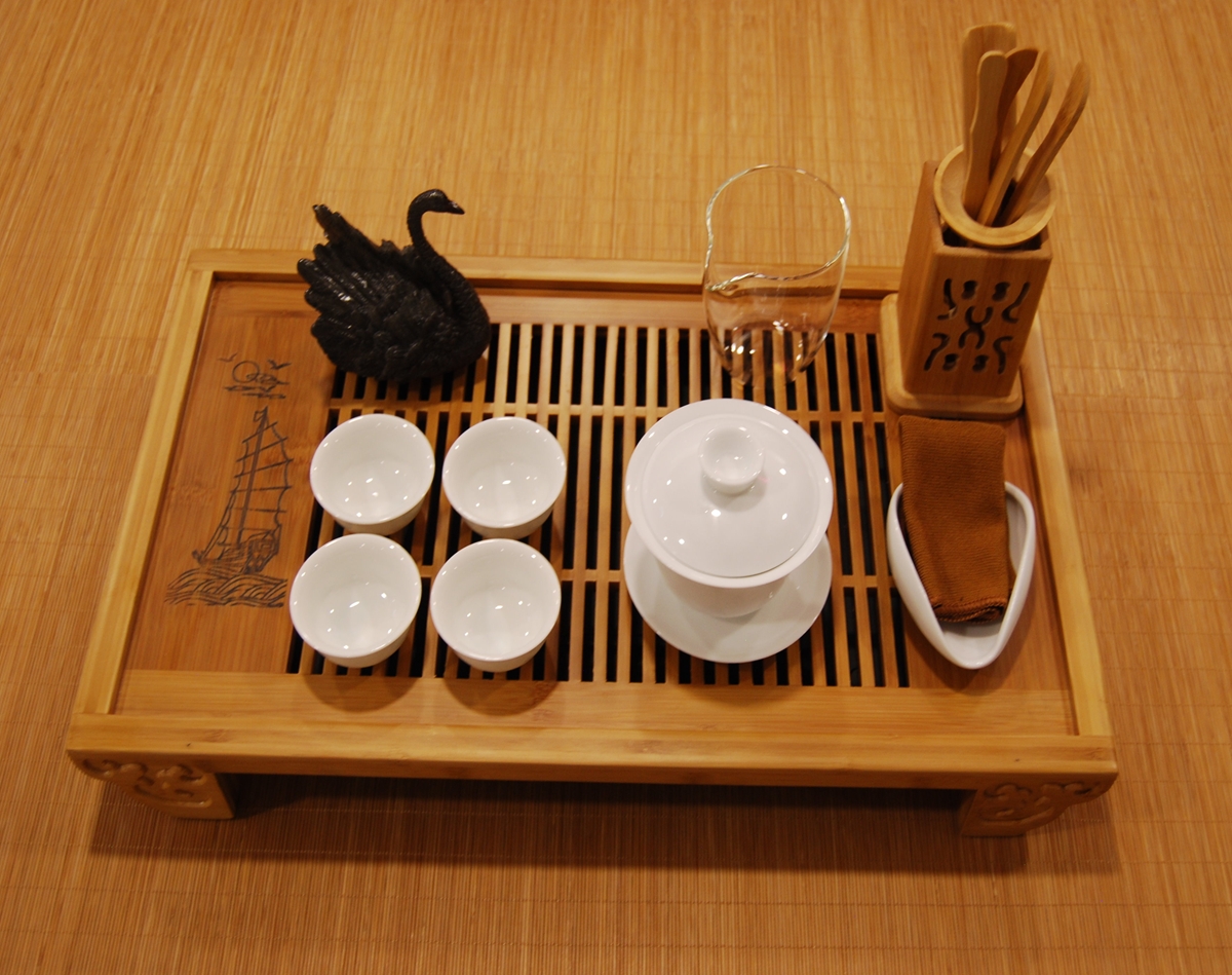 Ceremonial tea set with porcelain gaiwan, glass fairness cup, and bamboo tea tray