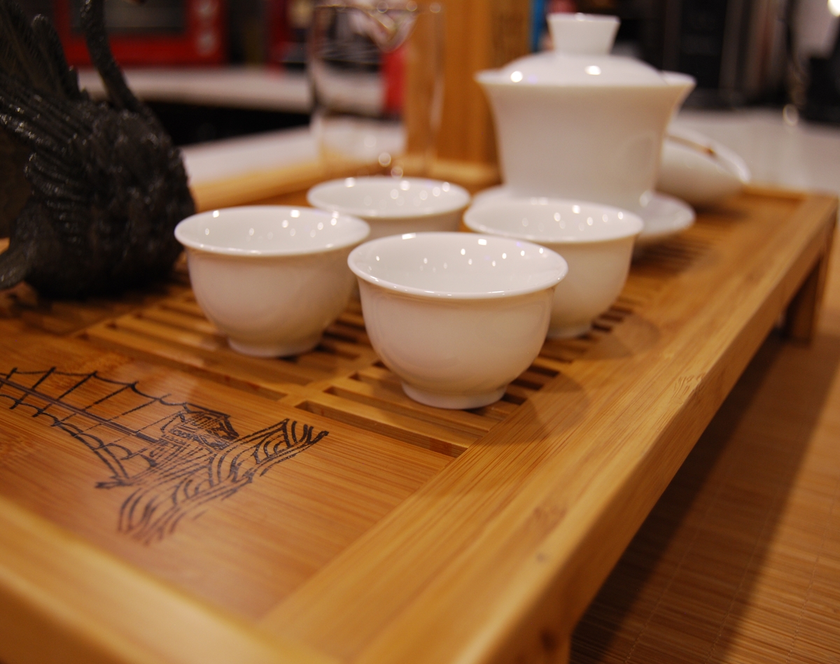 The Clear Flow Ritual Set arranged for ceremonial tea practice with porcelain gaiwan, tea tools, fairness cup, and swan tea pet