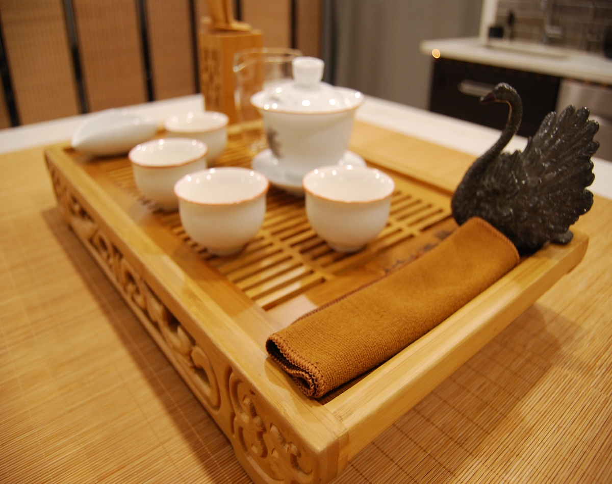 The Quiet Brush Ritual Set arranged for ceremonial tea practice with painted porcelain gaiwan, glaze cups, fairness cup, and swan tea pet