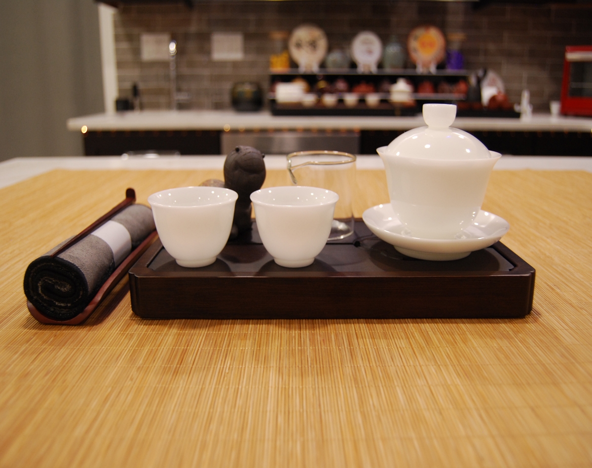 The Quiet Mind Ritual Set arranged for ceremonial tea practice with white porcelain gaiwan, cups, glass fairness cup, and dark tray
