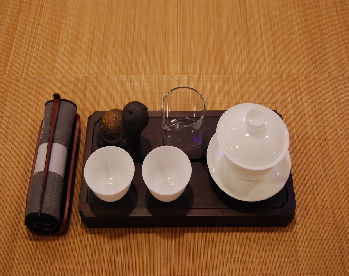 Compact ceremonial tea set with white porcelain gaiwan, cups, glass fairness cup, and dark gongfu tea tray box